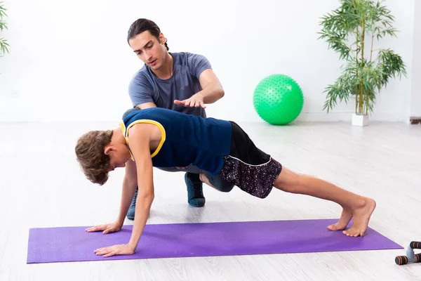 Jovem pai e seu filho fazendo exercícios — Fotografia de Stock