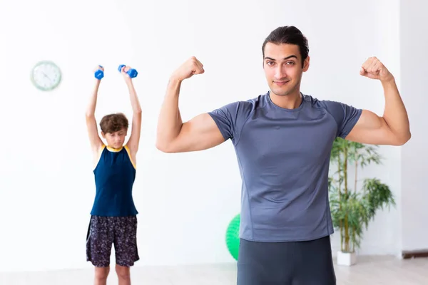 Jovem pai e seu filho fazendo exercícios — Fotografia de Stock