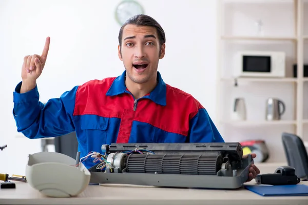 Jonge reparateur repareert airconditioner bij garantiecentrum — Stockfoto