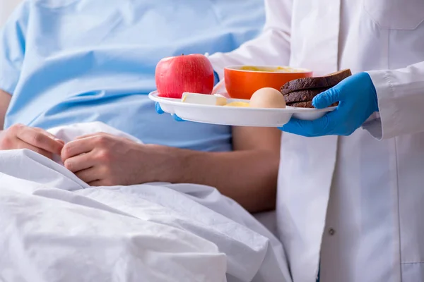 Paciente do sexo masculino que come alimentos no hospital — Fotografia de Stock