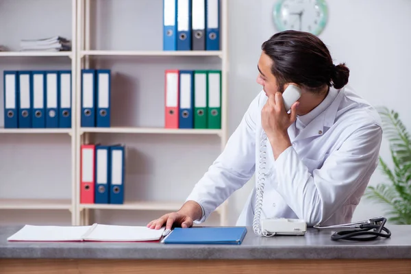 Hastanedeki resepsiyondaki genç erkek doktor. — Stok fotoğraf