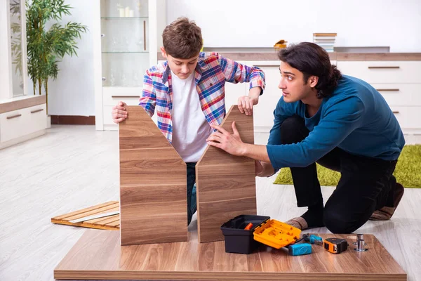 Young carpenter teaching his son