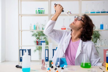 Laboratuvarda çalışan komik erkek kimyager.