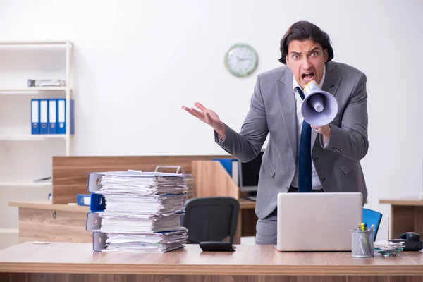 Joven empleado masculino infeliz con el trabajo excesivo — Foto de Stock