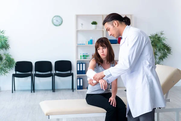 Mujer joven visitando médico traumatólogo masculino — Foto de Stock