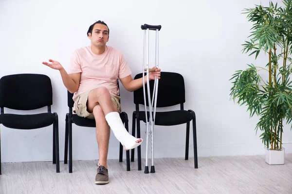 Young injured man waiting for his turn in hospital hall — Stock Photo, Image