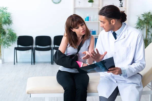 Mujer joven visitando médico traumatólogo masculino —  Fotos de Stock