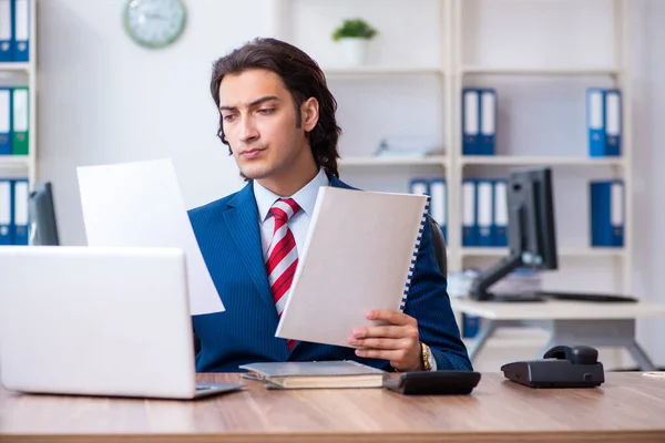 Jonge mannelijke zakenman werkzaam in het kantoor — Stockfoto