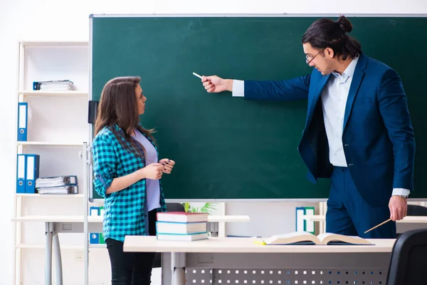 Jonge knappe leraar en vrouwelijke student in de klas — Stockfoto