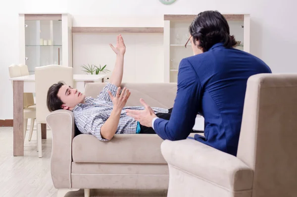 Jovem paciente do sexo masculino discutindo com psicólogo problema pessoal — Fotografia de Stock