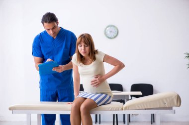 Hamile kadın, erkek doktor jinekoloğu ziyaret ediyor.