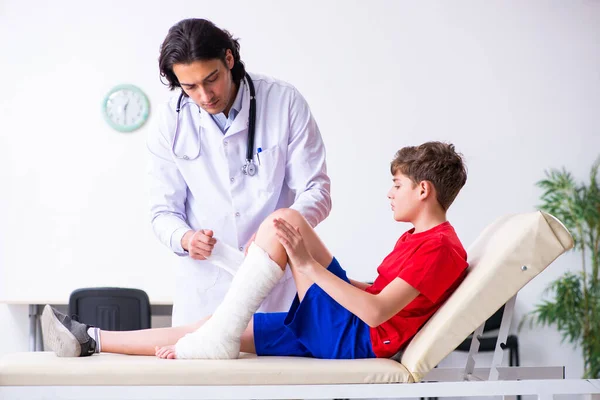 Noga ranny chłopiec odwiedzenie młody lekarz traumatolog — Zdjęcie stockowe