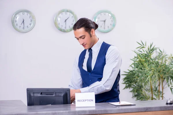 Young man receptionist at the hotel counter — Stock Photo, Image