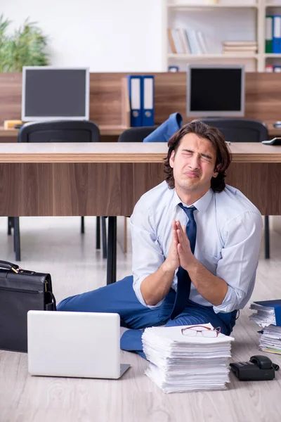 Jeune employé masculin et trop de travail au bureau — Photo