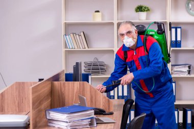 Ofiste haşere kontrolü yapan profesyonel bir müteahhit.