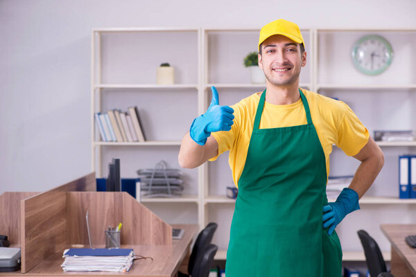 Молодой мужчина-подрядчик убирает офис