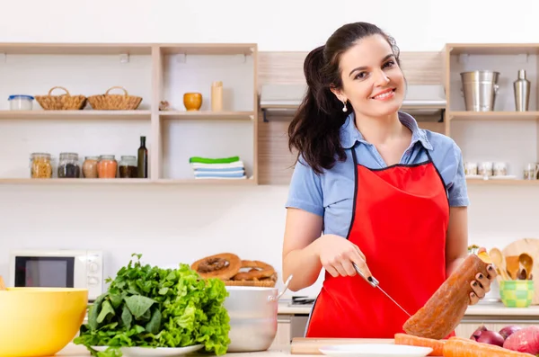 Jovem com legumes na cozinha — Fotografia de Stock