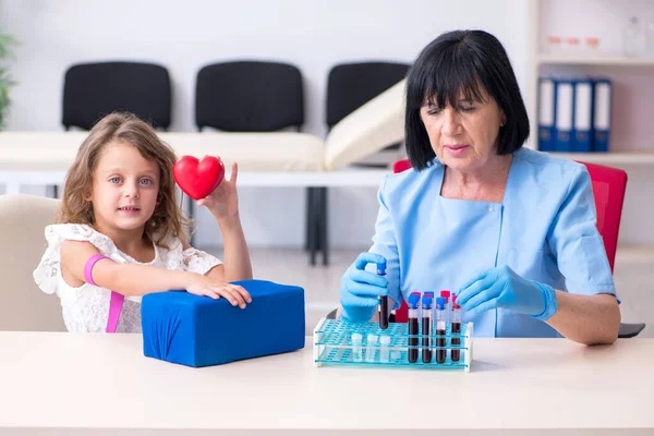 Menina visitando velho médico feminino — Fotografia de Stock