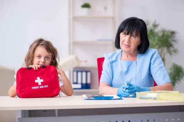 Petite fille visitant un vieux médecin féminin — Photo