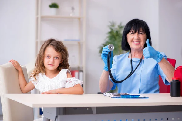 Bambina in visita vecchio medico femminile — Foto Stock