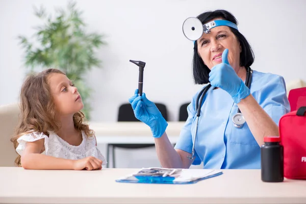 Little girl visiting old female doctor — Stock Photo, Image