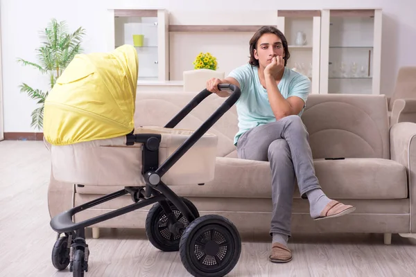 Young man looking after baby in pram — Stock Photo, Image