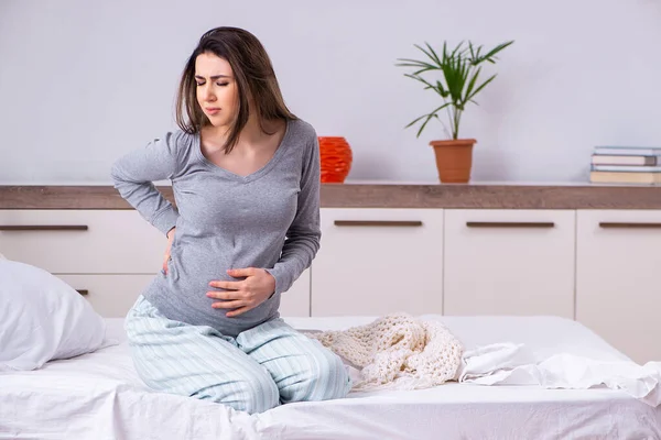 Jonge zwangere vrouw in de slaapkamer — Stockfoto