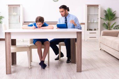 Baba oğlunun sınava hazırlanmasına yardım ediyor.