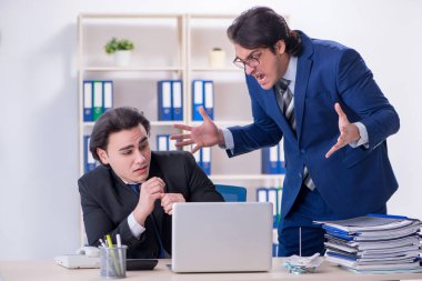 Patron ve erkek asistanı ofiste çalışıyor.