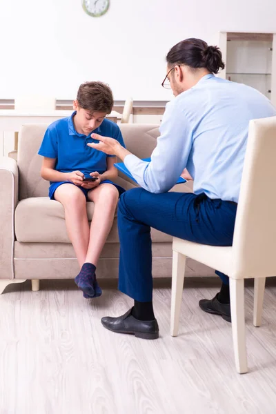 Internet addicted boy visiting male doctor — Stock Photo, Image