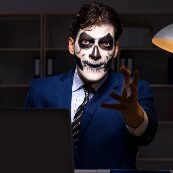 Der Geschäftsmann mit der gruseligen Gesichtsmaske arbeitet spät im Amt — Stockfoto