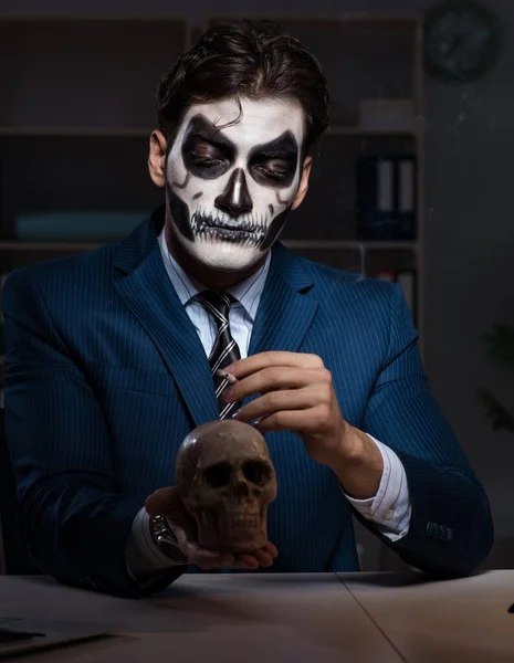 Biznesmen z przerażającą maską pracujący do późna w biurze — Zdjęcie stockowe