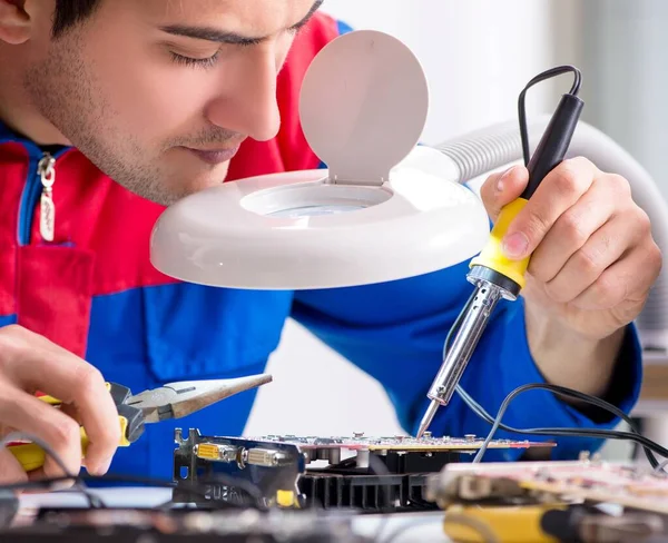 Professional repairman repairing computer in workshop