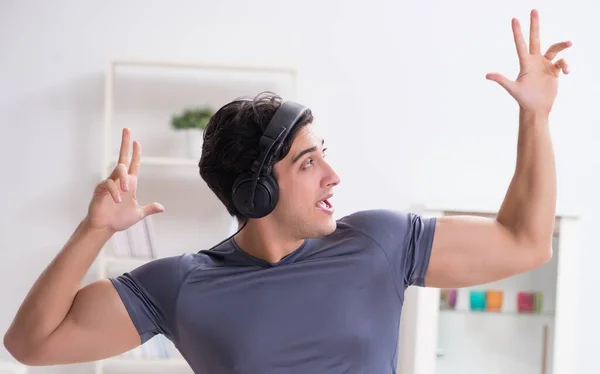 Man idrottar hemma och lyssnar på musik — Stockfoto