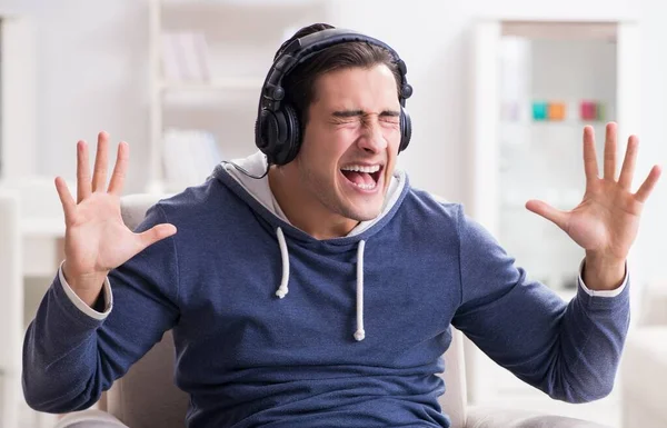 Jovem ouvindo música em casa — Fotografia de Stock