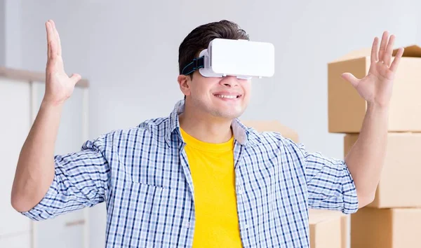 Young man wearing VR glasses moving in new apartment — Stock Photo, Image