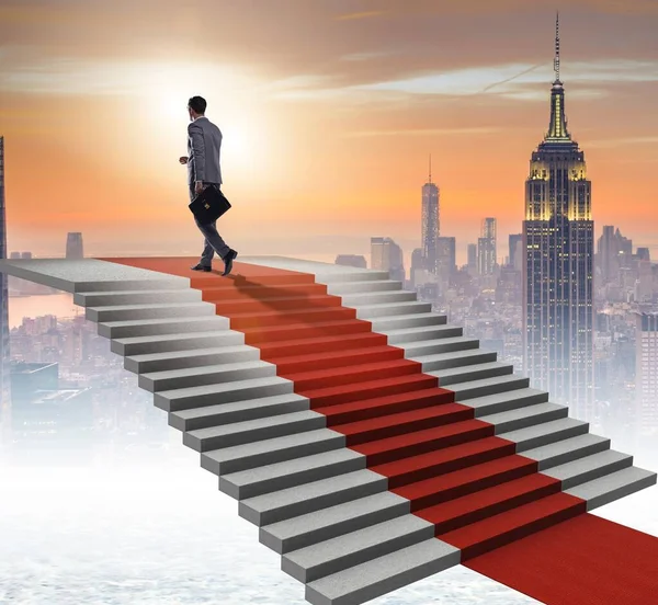 Young businessman climbing stairs and red carpet — Stock Photo, Image