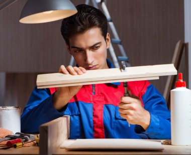 Genç adam ahşap parçaları DIY konseptinde yapıştırıyor.
