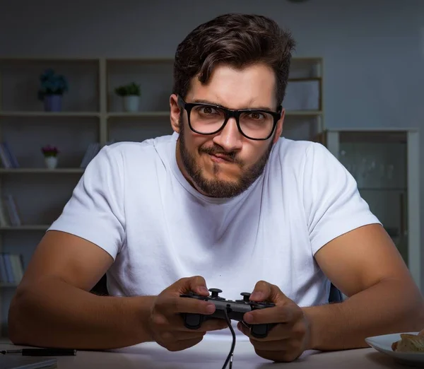 Den unge mannen spelar spel långa timmar sent på kontoret — Stockfoto