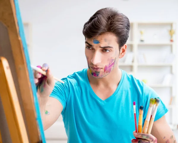 Jonge grappige kunstenaar werkt aan nieuw schilderij in zijn atelier — Stockfoto