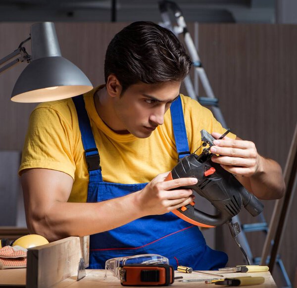 The worker working in repair workshop in woodworking concept