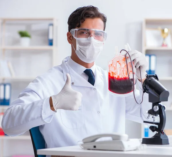 Médico trabajando con muestras de sangre en el laboratorio de la clínica hospitalaria —  Fotos de Stock