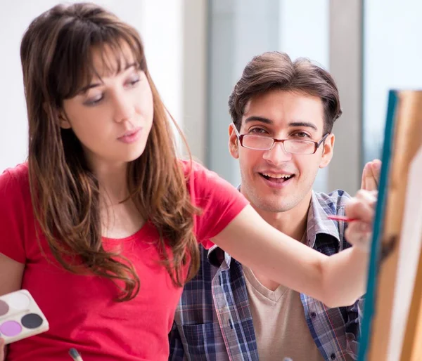 De kunstenaar coaching student in schilderles in studio — Stockfoto