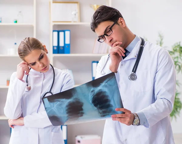 Dwóch lekarzy badających zdjęcia rentgenowskie pacjenta w celu rozpoznania — Zdjęcie stockowe