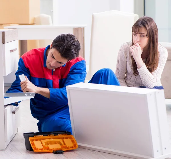 Contractor repairman assembling furniture under woman supervisio — Stock Photo, Image