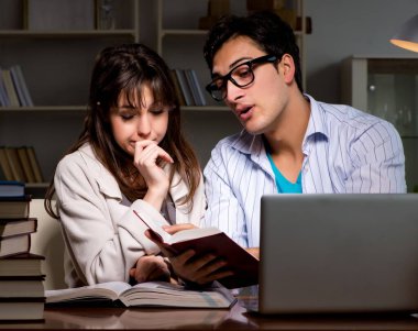 İki öğrenci geç saatlere kadar çalışıp sınavlara hazırlanıyor.