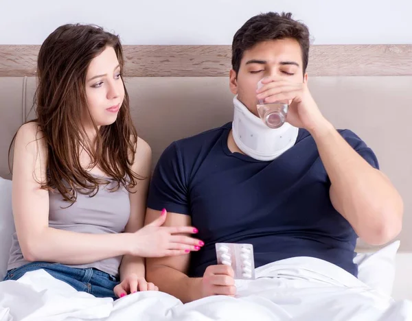 De liefhebbende vrouw zorgt voor gewonde man in bed — Stockfoto