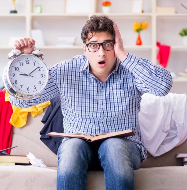 Genç adam dağınık bir odada çalışıyor.