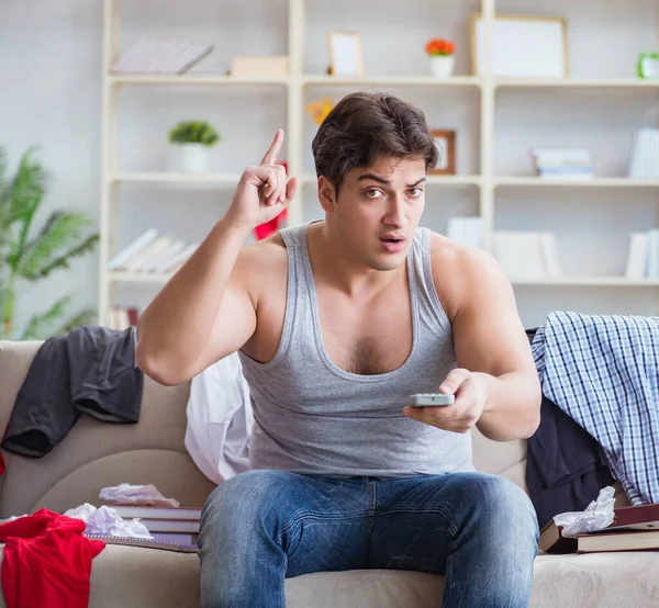 Joven trabajando estudiando en una habitación desordenada — Foto de Stock