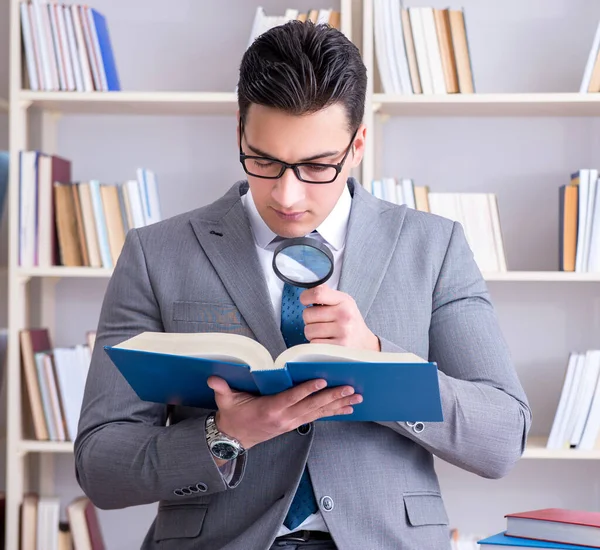 BWL-Student mit der Lupe beim Lesen eines Buches — Stockfoto